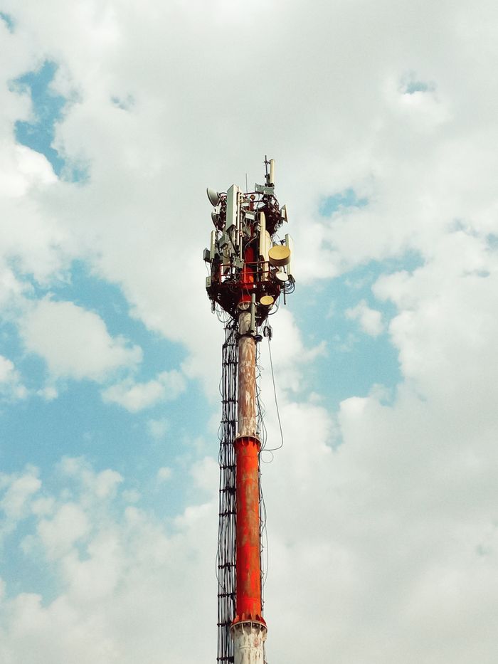 services-04 Low-angle view of a cell tower against a cloudy blue sky in Lahore, Pakistan.