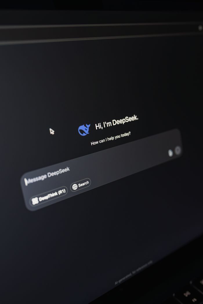services-02 Close-up of a laptop displaying an AI interface with a chatbot prompt in dark mode.